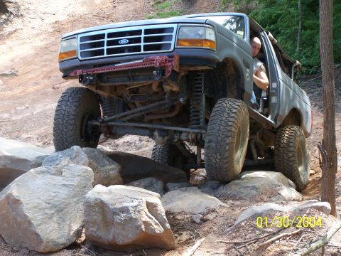 1979 Ford F-150 - This modified Ford Bronco is navigating a rocky trail with its driver visible.