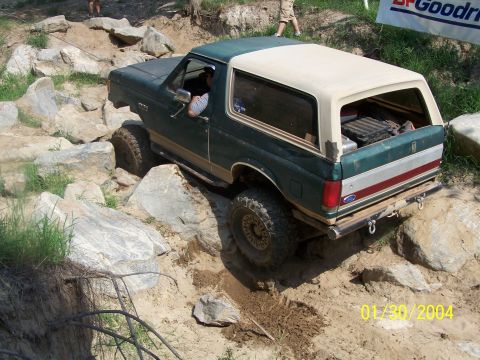 1979 Ford F-150 - This Ford Bronco is tackling a challenging off-road course with large rocks and dirt.