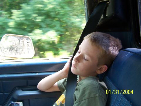 1979 Ford F-150 - A young boy sleeps soundly in the passenger seat of a vehicle, with the date 01/31/2004 visible on a timestamp.