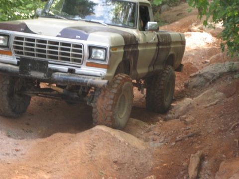 1979 Ford F-150 - This 1979 Ford F-150 is navigating a challenging off-road course with large tires.
