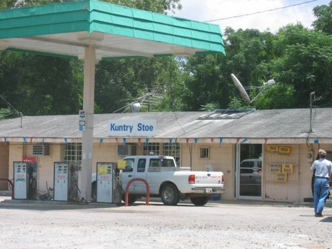1992 Ford Mustang - A white pickup truck is parked at the gas pumps outside a country store with a satellite dish on the roof.