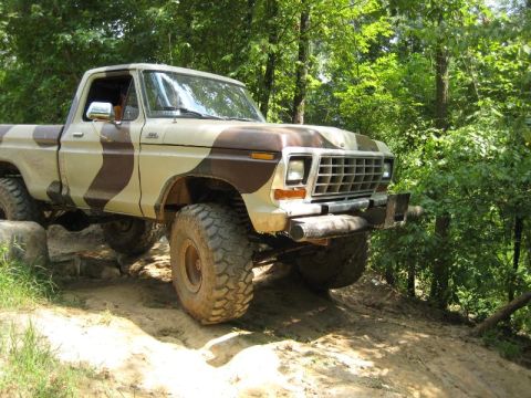 1979 Ford F-150 - This 1979 Ford F-150 pickup truck is navigating an off-road trail with large tires.