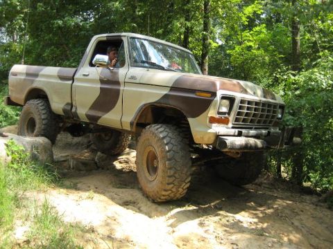 1979 Ford F-150 - This modified pickup truck is navigating a challenging off-road course with large tires and a lifted suspension.