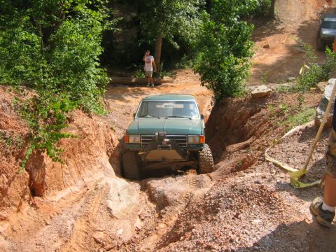 1992 Ford Mustang - Off-road truck navigates a challenging dirt trail with steep banks.