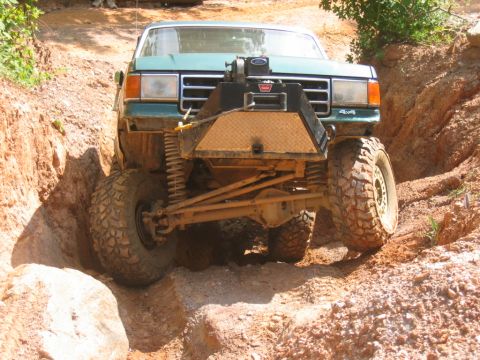 1992 Ford Mustang - This modified truck navigates a challenging off-road course, equipped with a winch for assistance.
