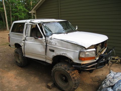 1979 Ford F-150 - This white Ford Bronco has significant body damage and appears to be modified for off-road use.