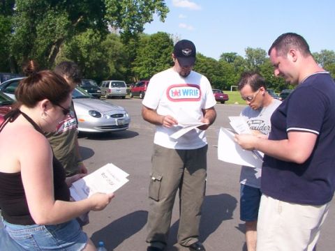 1998 Ford Taurus - Group of people reviewing documents in a parking lot with cars in the background.