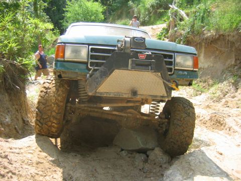 1992 Ford Mustang - This modified 1992 Ford F-series truck tackles a challenging off-road course, demonstrating its capabilities.