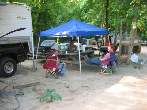 1992 Ford Mustang - People enjoy a day at a campsite with an RV and a canopy providing shade.