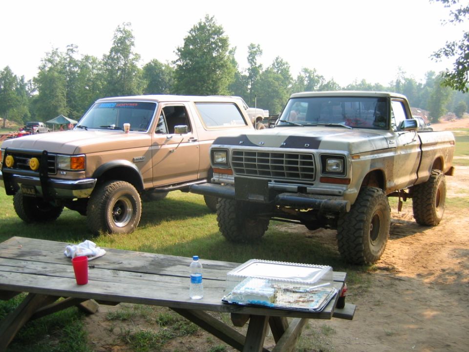Tan Ford Bronco and tan Ford pickup truck parked side-by-side outdoors