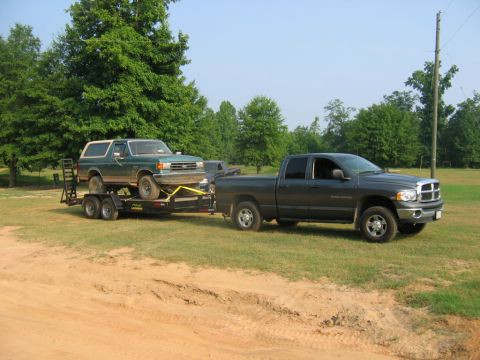 1992 Ford Mustang - A 1992 Ford Bronco is transported on a trailer by a Dodge Ram pickup truck.