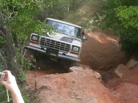 1990 Ford Bronco - This Ford Bronco navigates a challenging off-road terrain with steep inclines and loose dirt.
