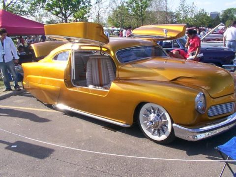 1998 Ford Taurus - A gold custom car with a roof rack and open door is parked on asphalt.