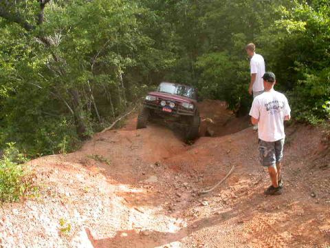 1990 Ford Bronco - Off-roading adventure with a red SUV navigating a challenging dirt trail.