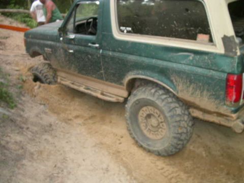 1990 Ford Bronco - This Ford Bronco is stuck in the mud, with its front wheel submerged in the dirt.
