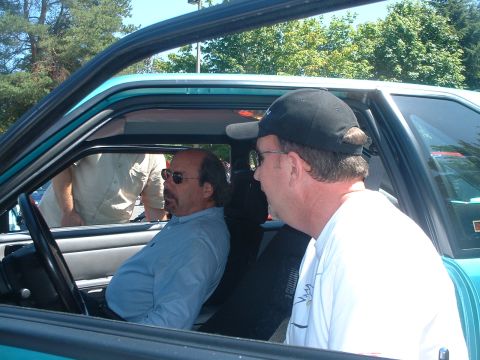 2000 Ford Crown Victoria - Two men are inside a car, one in the driver's seat and the other in the passenger seat.