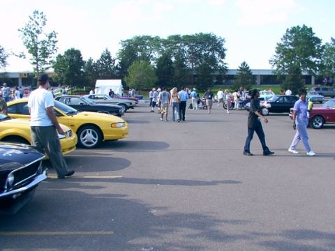 1998 Ford Taurus - Outdoor car show event with attendees mingling among various parked automobiles.