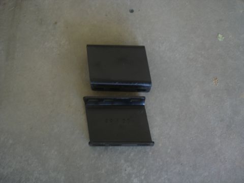 1987 Ford Bronco - Two black metal brackets are shown on a concrete surface. The bottom bracket has the numbers "40100" stamped on its surface.