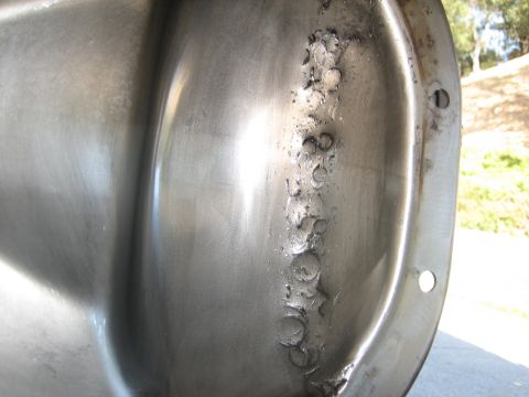 1995 Ford Bronco - A close-up view of the inside of a differential cover, showing some pitting and rough texture along one side. The cover is made of metal an…