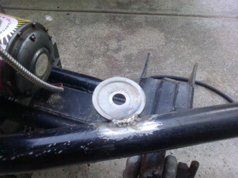 1995 Ford Bronco - A close-up view of a metal pipe that has been welded to a black frame. A circular metal piece with a hole in the center is attached to the…