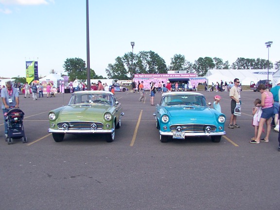 Green and blue 1955 Ford Thunderbirds parked front view