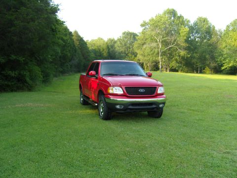 2007 Ford Mustang - Photograph of a red Ford pickup truck in a field, not a technical document.