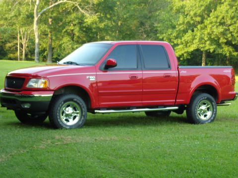 2007 Ford Mustang - Photograph of a red Ford F-150 crew-cab pickup, front three-quarter view on a lawn.