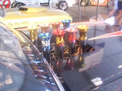 1998 Ford Taurus - Custom intake trumpets with 'Bif', 'Baf', 'Zaz', and 'Po' visible are mounted on a dark-colored vehicle.