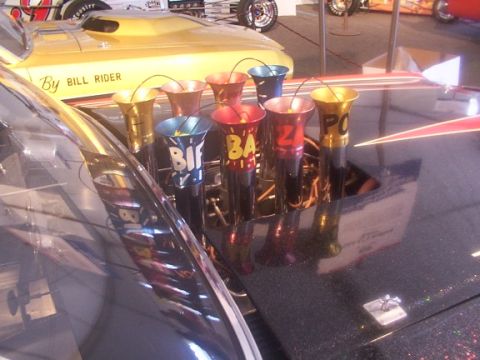 1998 Ford Taurus - Custom exhaust pipes with lettering are visible on a car's hood.