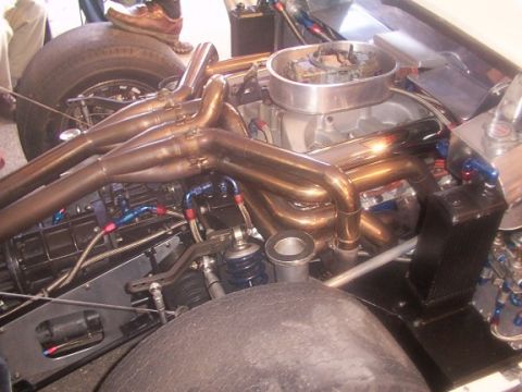 1998 Ford Taurus - Engine bay detail custom exhaust headers and performance parts. Supermotors.net logo is present.