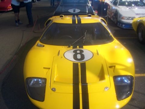 1998 Ford Taurus - A yellow race car with black stripes and the number 8 is parked next to other vehicles.