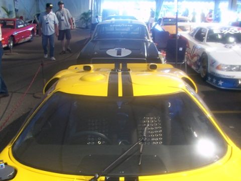 1998 Ford Taurus - A yellow race car with black stripes is parked at an event with other vehicles visible.