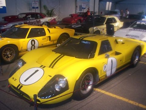 1998 Ford Taurus - Multiple vintage yellow race cars are displayed indoors, with one prominent car in the foreground.