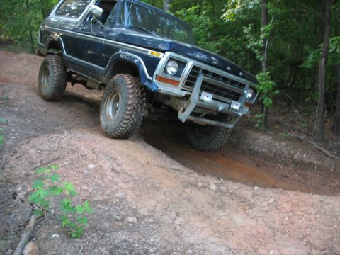 1978 Ford Bronco - This 1978 Ford Bronco is navigating a steep, muddy trail through a wooded area.