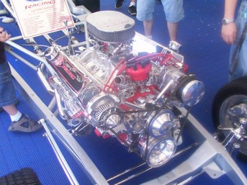 1998 Ford Taurus - A highly polished engine with chrome components and red accents is displayed, likely at a car show.