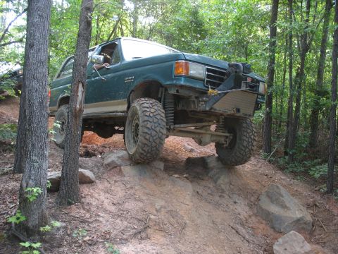1978 Ford Bronco - This modified SUV is shown tackling a challenging rocky trail, demonstrating its off-road capabilities.