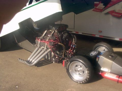 1998 Ford Taurus - Close-up of a drag racing engine and front wheel assembly with visible branding.