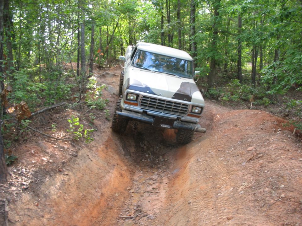 Tan and camouflage 1978 Ford Bronco on a dirt trail