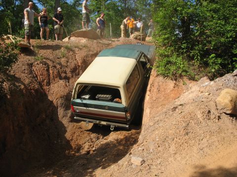 1978 Ford Bronco - A 1978 Ford Bronco tackles a challenging off-road trail with onlookers observing from above.