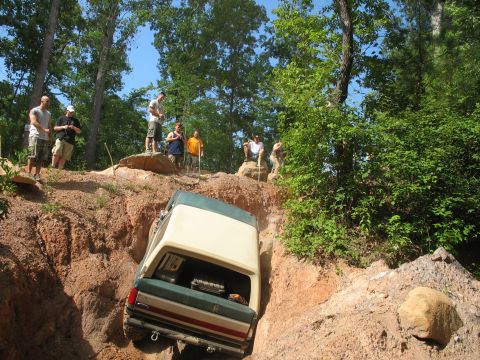 1978 Ford Bronco - A group of people watch as a vehicle navigates a challenging off-road trail.