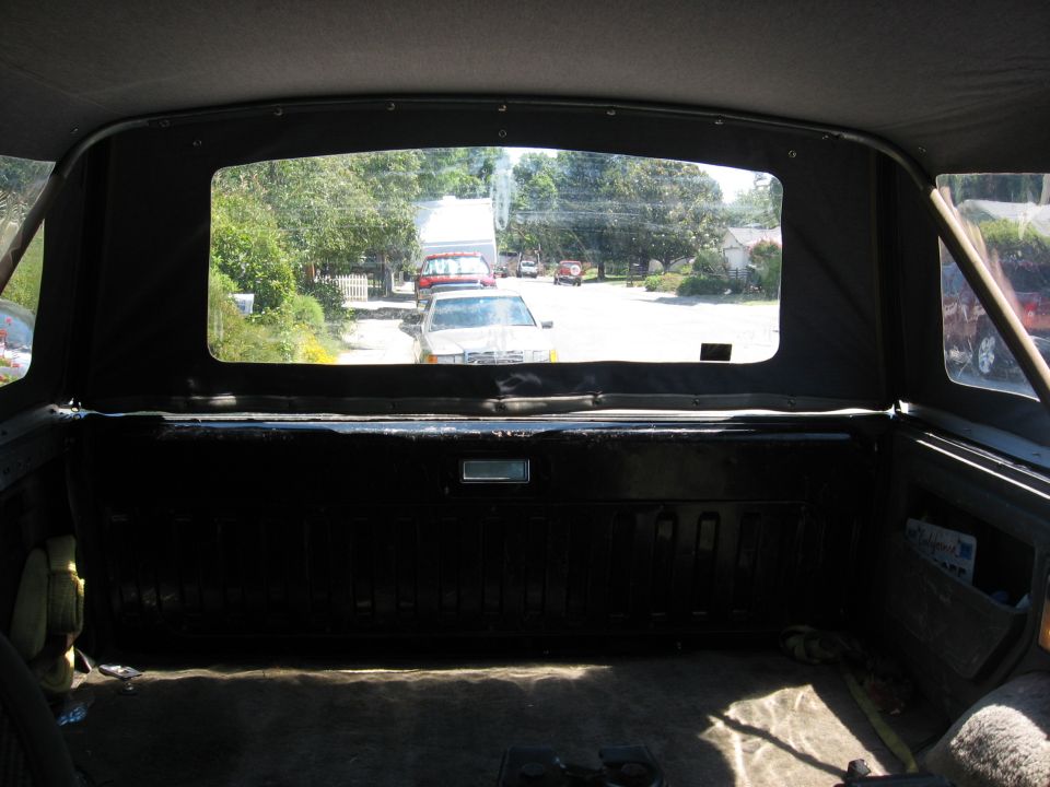 Interior rear cargo view of a Bronco looking out over the black tailgate to a driveway
