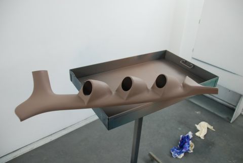 1996 Ford Bronco - A tan gauge pod designed to hold three gauges is shown on a metal tray, likely awaiting installation.