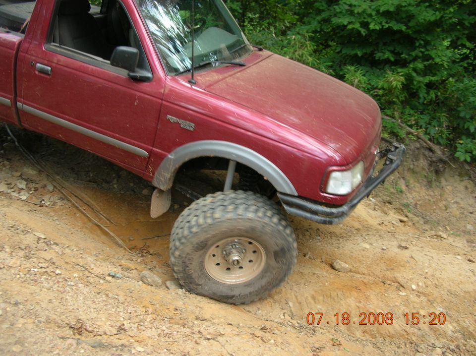 Red pickup truck with lifted suspension on a dirt trail