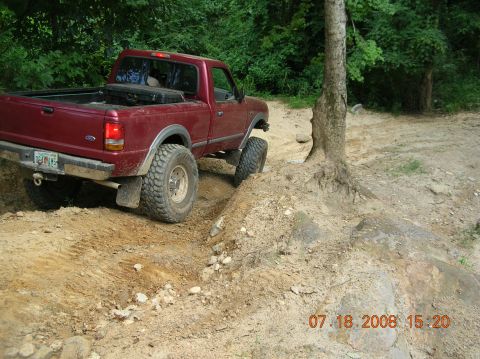 1991 Ford F-150 - 1991 Ford F-150 navigating an off-road trail with significant articulation.