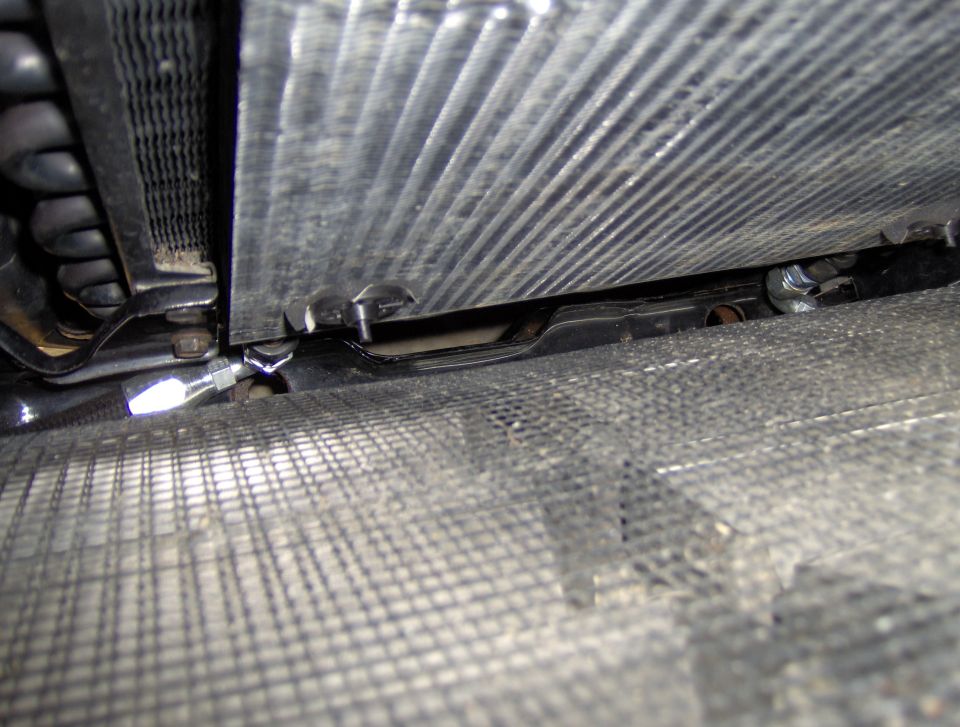 Close-up of radiator and transmission cooler lines with metal mesh below