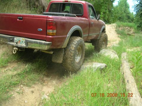 1991 Ford F-150 - Red 1991 Ford Ranger pickup truck navigating an off-road trail with large tires.