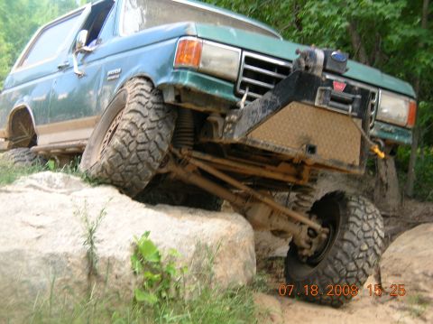 1991 Ford F-150 - This modified Ford Bronco is navigating a challenging rocky terrain.