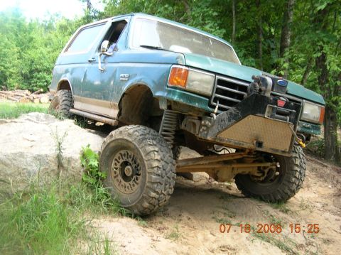 1991 Ford F-150 - This modified Ford Bronco navigates a rocky trail, its off-road capabilities.