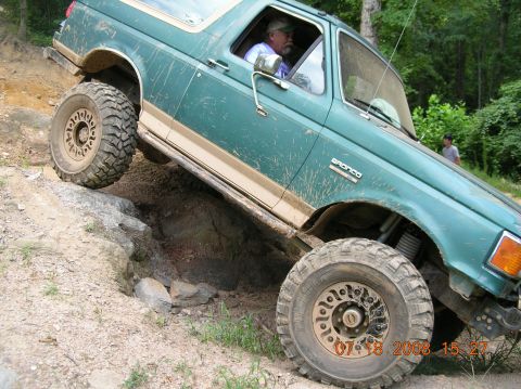 1991 Ford F-150 - Green 1991 Ford Bronco navigating a challenging rocky off-road course.