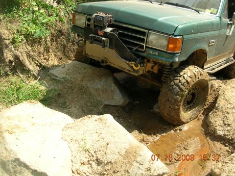 1991 Ford F-150 - This Ford F-150 is shown off-roading on a challenging course with large rocks and mud.